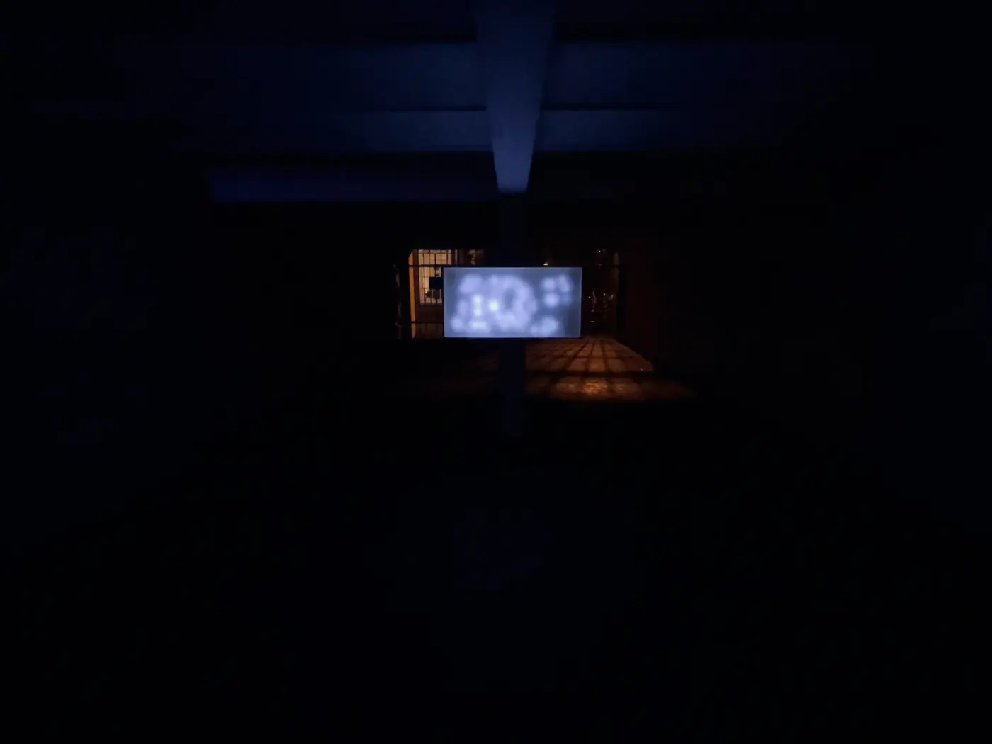 A glass-topped box of blurred blue LEDs glowing at the end of a dark corridor.